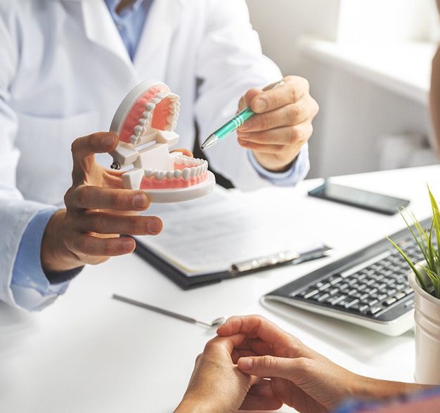 A dentist discussing the possibility of dental implants with a patient during a consultation