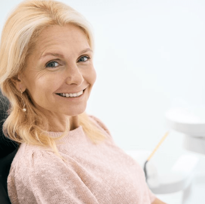 a patient smiling after receiving implant dentures in Jacksonville