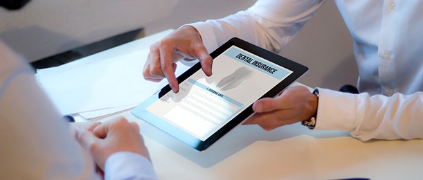 Dentist holding a tablet showing dental insurance information