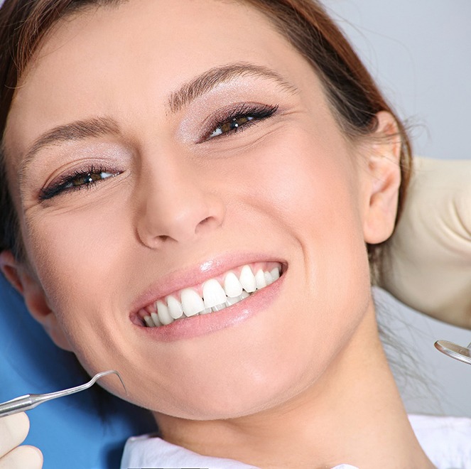 Smiling woman receiving dental exam from implant dentist in Jacksonville
