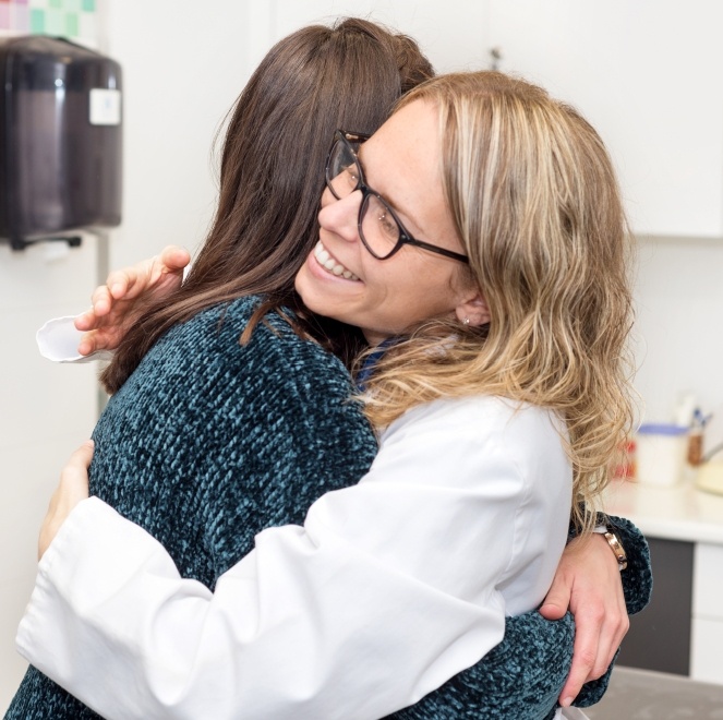 Dentist giving dental patient a hug