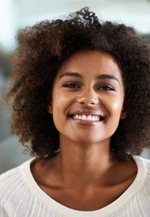 a woman smiling after getting dental implants near San Marco