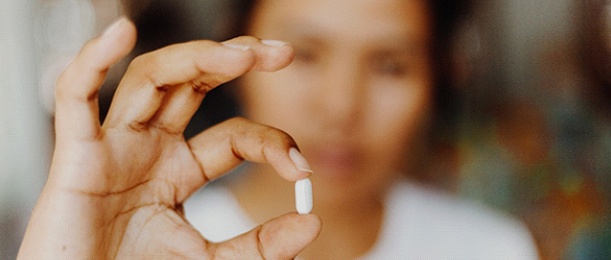woman holding up oral conscious sedation pill in Jacksonville