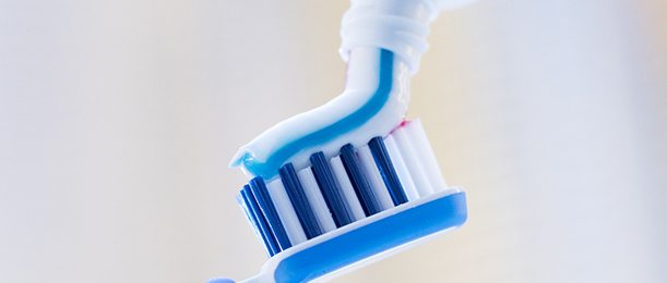 Close up of toothpaste being placed on toothbrush
