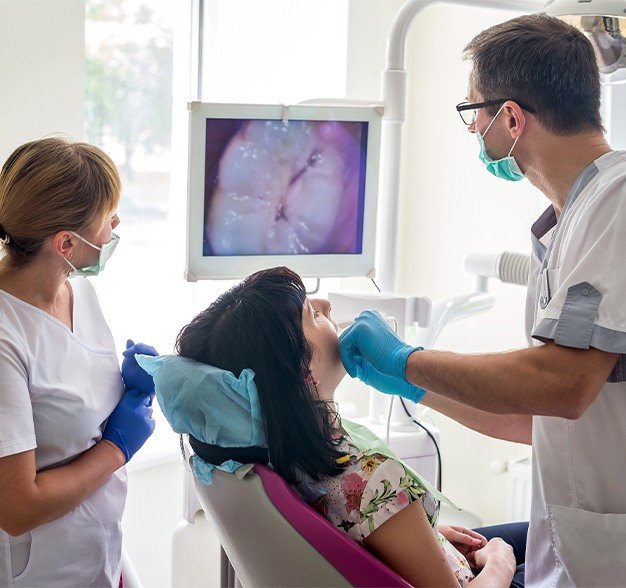 Patient dentist and team member looking at intraoral images