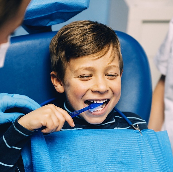 Child practicing tooth brushing during children's dentistry visit