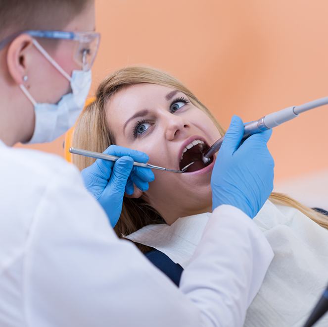 Dentist checking patient's dental sealants