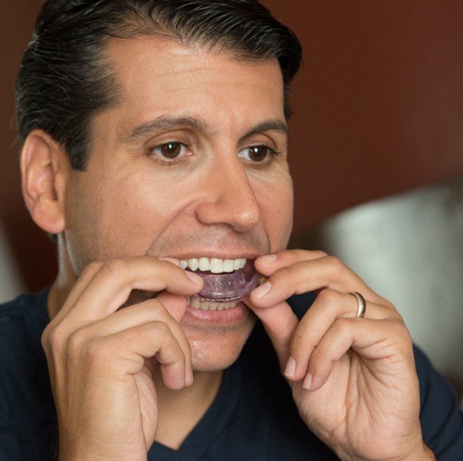 Man placing a nightguard for teeth grinding