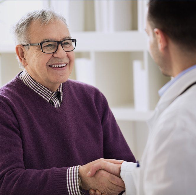 Older man shaking hands with sedation dentist