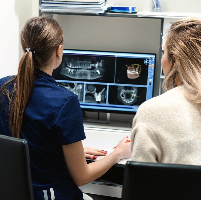 Dentist and team member looking at dental x-rays