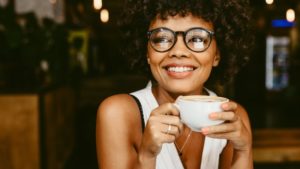 smiling woman sipping a cup of coffee