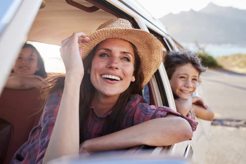 woman smiling in car with porcelain veneers