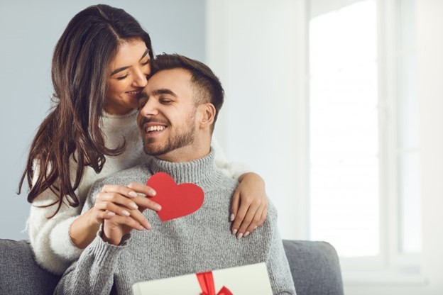 smiling couple holding a paper heart