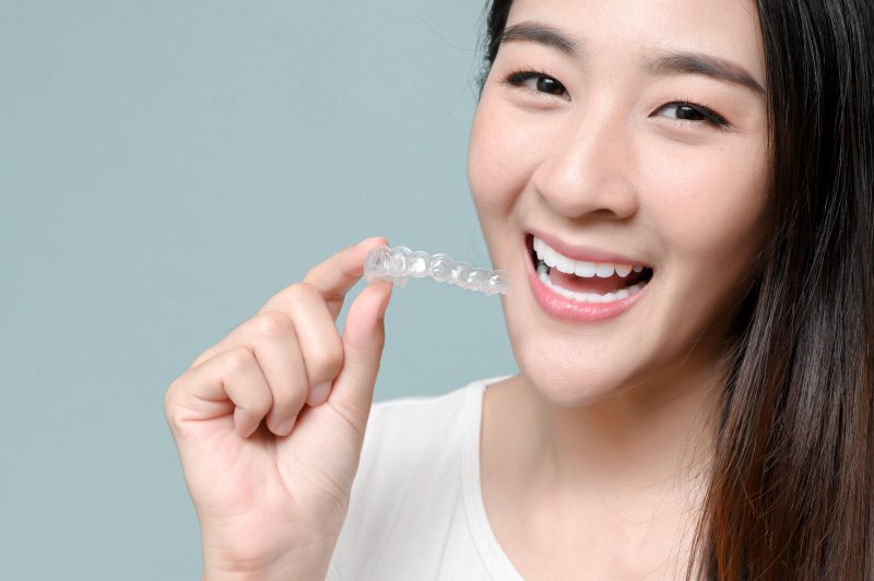 person holding Invisalign aligner