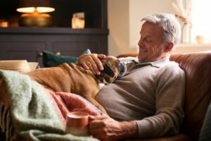 a man relaxing on his couch with his dog